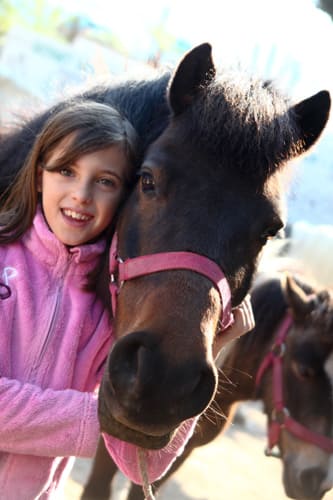 Photo d'une jeune fille à côté d'un poney