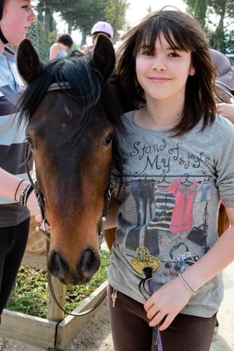Photo d'une fille à côté de son poney