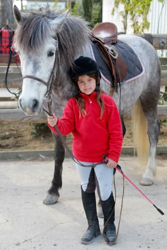 Jeune fille qui prend une photo avec son poney