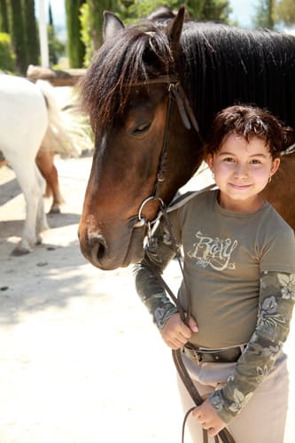 Photographie d'un enfant à côté d'un poney